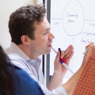 A man writing on a poster at a workshop